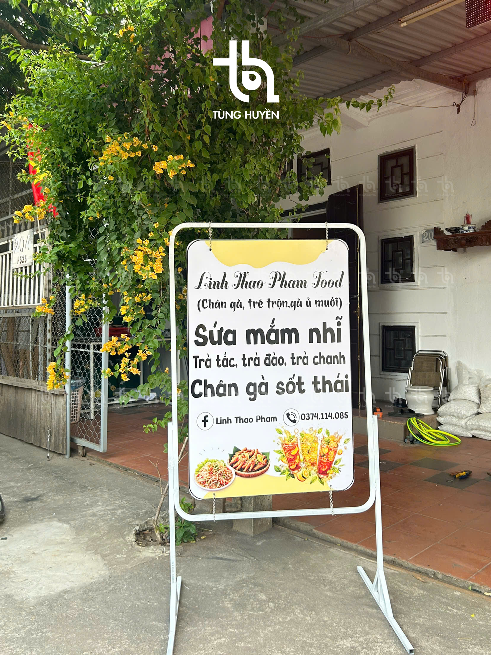 Standee khung sắt đặt trên vỉa hè trước cửa quán