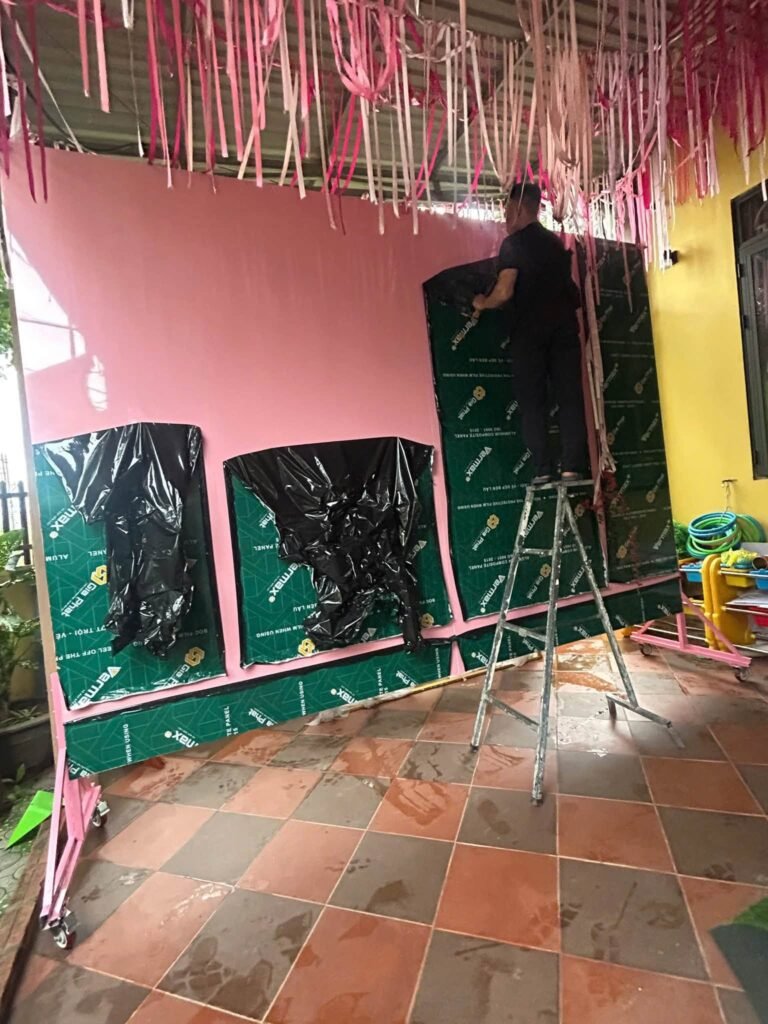 Dán tấm alu màu hồng lên khung sắt phông sân khấu di động